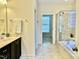 Well-lit bathroom featuring tiled floors, vanity, stand up shower, and a relaxing tub at 1549 Lily Creek Dr, Cary, NC 27518