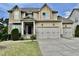 Charming two-story home features a three car garage, stone accents, and a manicured lawn at 1549 Lily Creek Dr, Cary, NC 27518