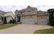 Two-story house featuring a two-car garage, stone accents and a well-maintained lawn at 1549 Lily Creek Dr, Cary, NC 27518