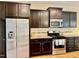 Kitchen with stainless steel appliances, dark wood cabinets, and a gas range at 1549 Lily Creek Dr, Cary, NC 27518