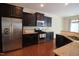 Kitchen features stainless steel appliances, dark cabinetry, granite countertops, and hardwood floors at 1549 Lily Creek Dr, Cary, NC 27518