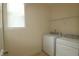 Practical laundry room with washer, dryer, overhead shelving, and a window for natural light at 1549 Lily Creek Dr, Cary, NC 27518