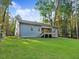 Backyard view of the home with a deck and spacious green lawn at 157 Gumtop Dr, Zebulon, NC 27597
