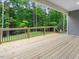 Wooden deck with black metal railings overlooking a serene backyard with mature trees at 157 Gumtop Dr, Zebulon, NC 27597