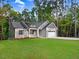 Beautiful single-story home showcases gray siding, black shutters, and lush green lawn surrounded by mature trees at 157 Gumtop Dr, Zebulon, NC 27597
