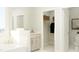 Bright bathroom with a tub, vanity, and an open closet with shelving at 1601 Goldfinch Perch Ln, Knightdale, NC 27545