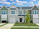 Charming townhome exterior showcasing a well-manicured lawn and attached garages at 162 Ripple Way # 322, Clayton, NC 27520
