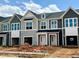 Street view of new construction townhomes with attached garages and neutral color schemes at 162 Ripple Way # 322, Clayton, NC 27520