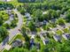 Aerial view showcasing a neighborhood with lush trees, well-maintained homes, and scenic streets at 205 Hornholly Way, Holly Springs, NC 27540