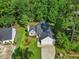 Aerial view of a cozy home featuring a well-manicured lawn and an attached two-car garage with driveway at 205 Hornholly Way, Holly Springs, NC 27540
