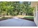 A spacious concrete patio leads to the backyard, featuring lush trees and a storage shed at 205 Hornholly Way, Holly Springs, NC 27540