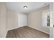 Neutral bedroom with wood-look floors and a window letting in natural light at 205 Hornholly Way, Holly Springs, NC 27540