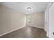This bedroom has hardwood floors, a light, and a single window bringing in natural light at 205 Hornholly Way, Holly Springs, NC 27540