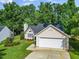 Charming single-story home featuring a well-manicured lawn and an attached two-car garage with driveway at 205 Hornholly Way, Holly Springs, NC 27540