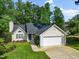 Charming single-story home featuring a well-manicured lawn and an attached two-car garage with driveway at 205 Hornholly Way, Holly Springs, NC 27540