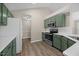 Modern kitchen featuring stainless steel appliances and green cabinets at 205 Hornholly Way, Holly Springs, NC 27540