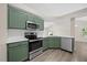 Modern kitchen with stainless steel appliances and bright green cabinets at 205 Hornholly Way, Holly Springs, NC 27540