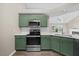 Updated kitchen with stainless steel appliances, white countertops and a view of the fireplace at 205 Hornholly Way, Holly Springs, NC 27540