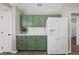 Well-lit kitchen featuring green cabinetry and a new white refrigerator at 205 Hornholly Way, Holly Springs, NC 27540