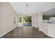 Open-concept living and dining area with hardwood floors, large windows, and backyard access at 205 Hornholly Way, Holly Springs, NC 27540