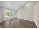The living room has hardwood floors, a light, and a glass door with three windows bringing in natural light at 205 Hornholly Way, Holly Springs, NC 27540