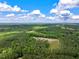Aerial view of the property and surrounding area with lots of green trees and bright blue skies at 2092 Winwood Farm Rd, Creedmoor, NC 27522