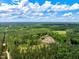 Aerial view of the property with a house surrounded by beautiful green trees and bright blue skies at 2092 Winwood Farm Rd, Creedmoor, NC 27522