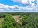 An aerial view shows the house and barn on a property surrounded by beautiful green trees at 2092 Winwood Farm Rd, Creedmoor, NC 27522