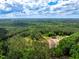 Aerial view of the property with a house surrounded by beautiful green trees and bright blue skies at 2092 Winwood Farm Rd, Creedmoor, NC 27522