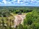 Stunning aerial view of a wooded estate featuring a log home and a large, cleared area perfect for expansion at 2092 Winwood Farm Rd, Creedmoor, NC 27522