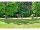 Picturesque backyard featuring a swing set surrounded by mature trees, offering a tranquil outdoor space at 2092 Winwood Farm Rd, Creedmoor, NC 27522