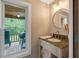 This bathroom features a tan vanity, speckled countertop, modern faucet, and a view of the outdoors at 2092 Winwood Farm Rd, Creedmoor, NC 27522