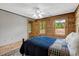 Bedroom featuring wood paneling, white ceiling, a ceiling fan, with natural light from outdoor views at 2092 Winwood Farm Rd, Creedmoor, NC 27522