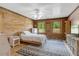 Charming bedroom featuring wood walls, two windows with great views, and a geometric patterned rug at 2092 Winwood Farm Rd, Creedmoor, NC 27522