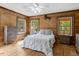 Inviting bedroom features wooden walls, matching dressers, and natural light from multiple windows at 2092 Winwood Farm Rd, Creedmoor, NC 27522
