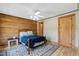 Comfortable bedroom with wood paneled accent wall, neutral paint, ceiling fan, and beautiful area rug at 2092 Winwood Farm Rd, Creedmoor, NC 27522