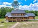 Charming two-story log home with a welcoming covered front porch and beautiful landscaping at 2092 Winwood Farm Rd, Creedmoor, NC 27522