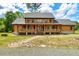 Charming two-story log home with a welcoming covered front porch and beautiful landscaping at 2092 Winwood Farm Rd, Creedmoor, NC 27522