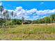 Charming log home with red barn, surrounded by fields and lush trees, under a bright blue sky with fluffy clouds at 2092 Winwood Farm Rd, Creedmoor, NC 27522