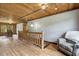 Hallway featuring wood-clad walls and ceilings with rustic wooden railing and a comfortable sitting area at 2092 Winwood Farm Rd, Creedmoor, NC 27522