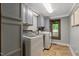 This laundry room features newer model washer and dryer, grey cabinetry, and a window at 2092 Winwood Farm Rd, Creedmoor, NC 27522