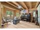Cozy living room with wood walls, wooden beams, wood floors, and vintage furniture, offering a rustic charm at 2092 Winwood Farm Rd, Creedmoor, NC 27522
