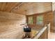 Living room showcasing wooden walls and ceilings with natural light from windows, and wooden railing at 2092 Winwood Farm Rd, Creedmoor, NC 27522