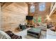 Comfortable living room with soaring wood plank walls, ceiling, two windows, and neutral furniture at 2092 Winwood Farm Rd, Creedmoor, NC 27522
