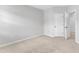 This bedroom features neutral carpet, light-colored walls, and a door at 2100 Curry Meadow Way, Durham, NC 27703