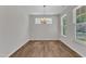 Open-concept dining room with wood floors, a chandelier, and two windows at 2100 Curry Meadow Way, Durham, NC 27703