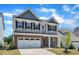 Beautiful two-story home featuring a brick facade and a well-maintained lawn at 2100 Curry Meadow Way, Durham, NC 27703