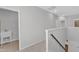 Upstairs hallway featuring neutral colors, carpet, and access to the utility room and bedrooms at 2100 Curry Meadow Way, Durham, NC 27703