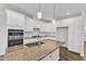 Bright kitchen features white cabinetry, granite countertops, stainless appliances, and a spacious island at 2100 Curry Meadow Way, Durham, NC 27703