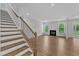 Open-concept living room with hardwood floors, fireplace, and staircase at 2100 Curry Meadow Way, Durham, NC 27703
